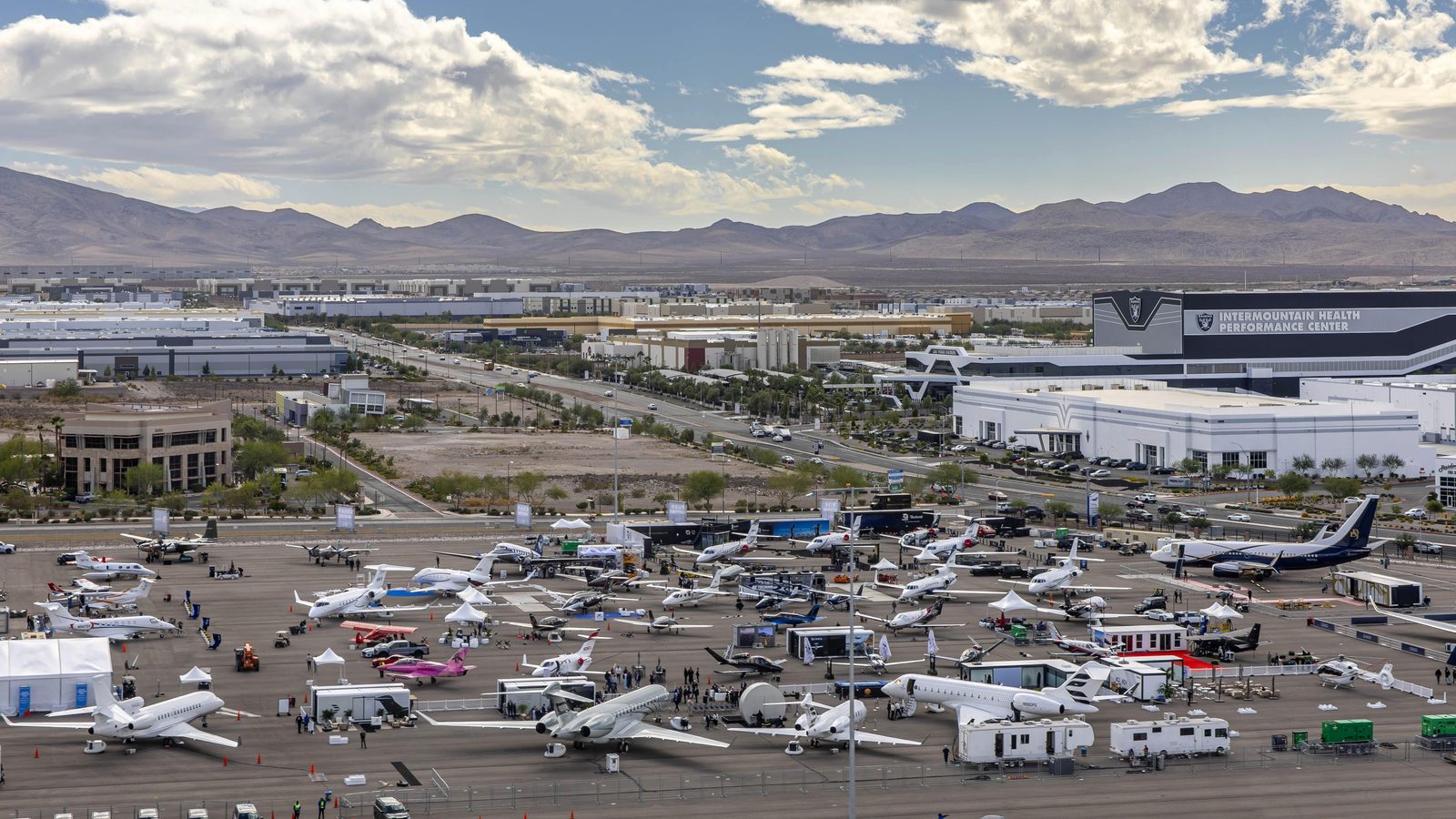 Business jets parked on the Aircraft Connection ramp at Henderson Executive Airport, desert mountains behind
